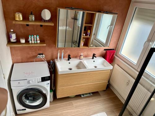 a bathroom with a washing machine and a sink at The Mandala Room in Thionville