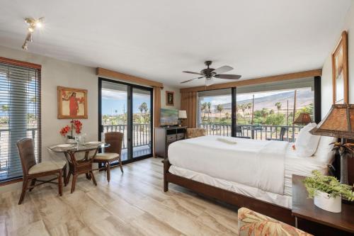 a bedroom with a bed and a table with chairs at Lahaina Shores 234 in Wainee