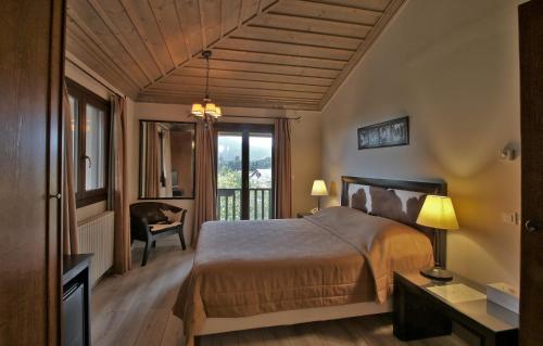 a bedroom with a bed and a desk and a chair at Boutique Hotel Skamnos Arachova in Arachova