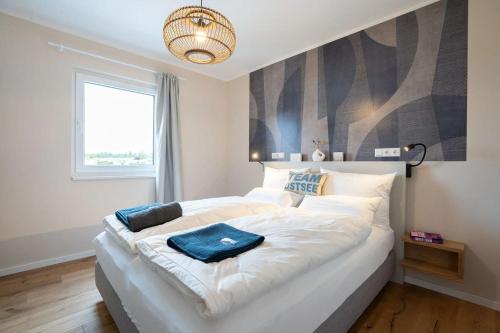 a large white bed in a room with a window at Campingland Ostsee in Schashagen