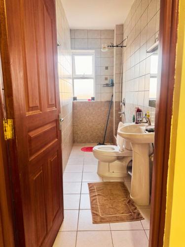 a bathroom with a toilet and a sink at Sunshine Home in Nanyuki
