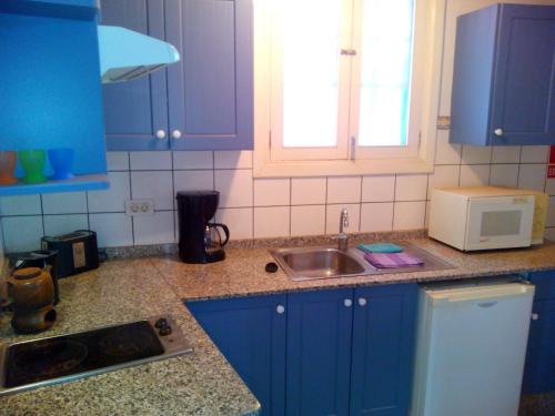 een keuken met blauwe kasten, een wastafel en een magnetron bij Casa Julián in Santa Cruz de la Palma