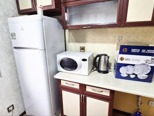 タシュケントにあるCHORSU komplex Hazrati Imamの電子レンジと冷蔵庫を備えたキッチンカウンター