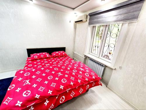 タシュケントにあるCHORSU komplex Hazrati Imamの窓付きの小さな部屋の赤いベッド1台分です。