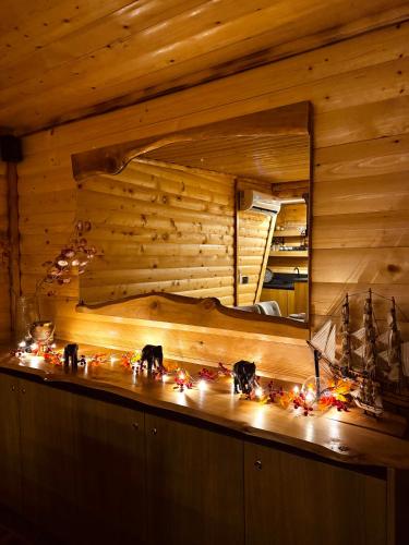 a room with a wooden wall and a counter with lights at Cozy Cabin House in Novi Pazar