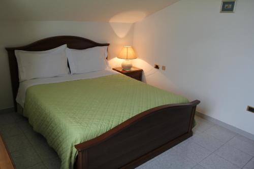 um quarto com uma cama com um cobertor verde e um candeeiro em Anna Rita B&B em Moie