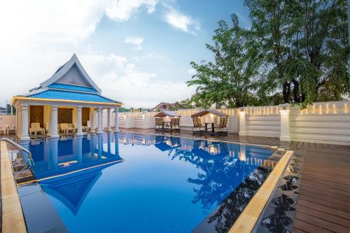 a swimming pool with a house and a building at Xinmylin Boutique in North Pattaya