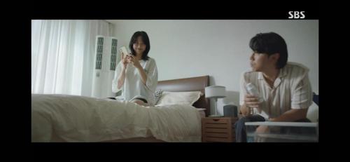 a man and a woman sitting on a bed playing a video game at Kintex 2rooms 3bed GTX Kintex17m 