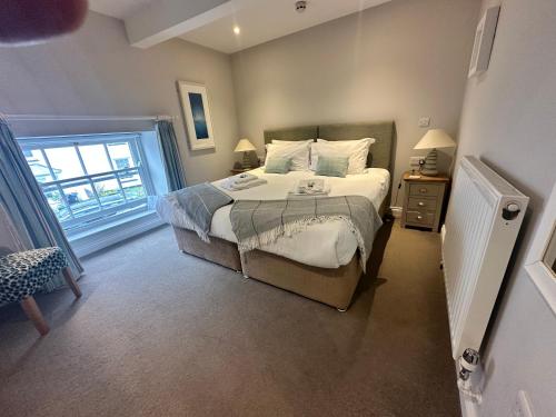 a bedroom with a large bed and a window at Plume of Feathers in Porthscatho