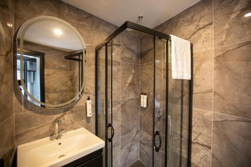 Un baño con ducha, lavabo y espejo. en Marlen Hotel Mavisehir, en Izmir