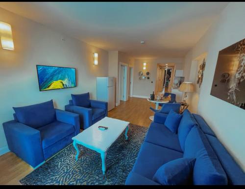 a living room with blue couches and a table at ORBI CITY Black Sea LUXURY hotel in Batumi