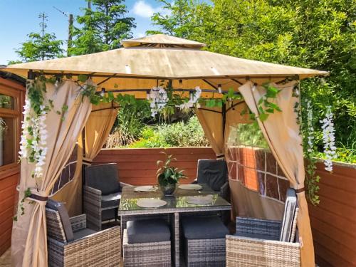 a gazebo with a table and chairs under it at Cow Boy Cabin - Uk47145 in Glasgow