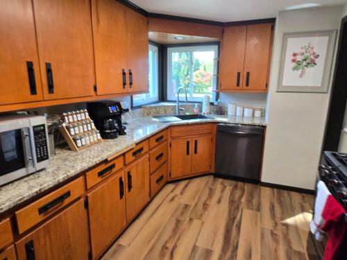 Una cocina con gabinetes de madera, un fregadero y un refrigerador. en Three Bedroom Ranch walking distance to Lambeau, en Green Bay