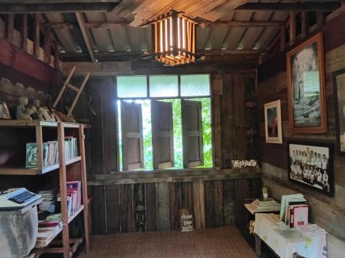a room with a window and a chandelier at hug pang mao homestay Lampang โฮมสเตย์ฮักปางมะโอ ลำปาง in Ban Cham Pu Loei