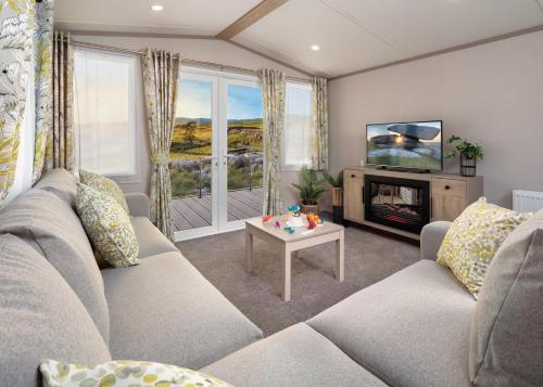 チャペル・セント・レオナルズにあるGolden Anchor Caravan Parkのソファとテレビのあるリビングルーム