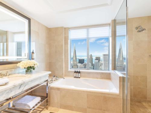 a bathroom with a large tub and a window at Fairmont San Francisco in San Francisco