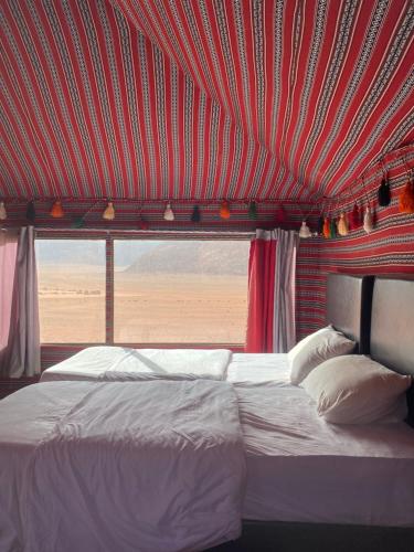a bed in a room with a red ceiling at Golden Camp Tours in Wadi Rum