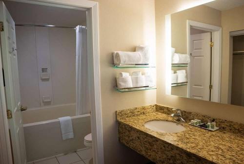 a bathroom with a sink and a shower and a mirror at Hawthorn Suites in Erie