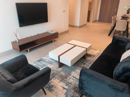 a living room with two couches and a flat screen tv at Erniesa in Accra
