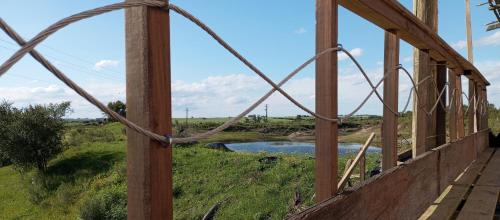 a wooden fence with a view of a river at Casa Campo in Cufré