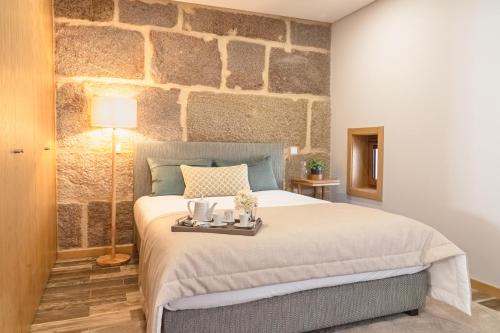 a bedroom with a large bed with a stone wall at LR Vintage 86 in Vila Real