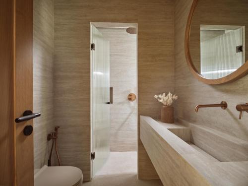 a bathroom with a sink and a toilet and a mirror at Oriana, Beachfront villa in Zakynthos Town