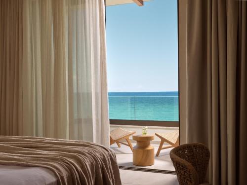 a room with a bed and a view of the ocean at Oriana, Beachfront villa in Zakynthos Town