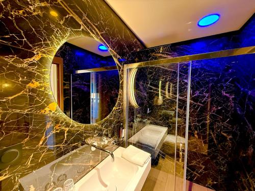 a bathroom with a tub and a sink and a mirror at Hôtel Le Mistral in Porto-Vecchio