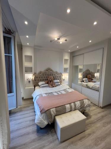 Un dormitorio con una cama con un osito de peluche encima. en Moutarde & Elégance de Dijon, en Dijon