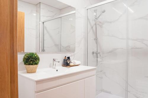 a white bathroom with a sink and a shower at LR Vintage 86 in Vila Real