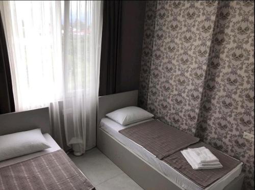 Una cama pequeña en una habitación con ventana. en apart hotel at sea, en Itʼkhvisi