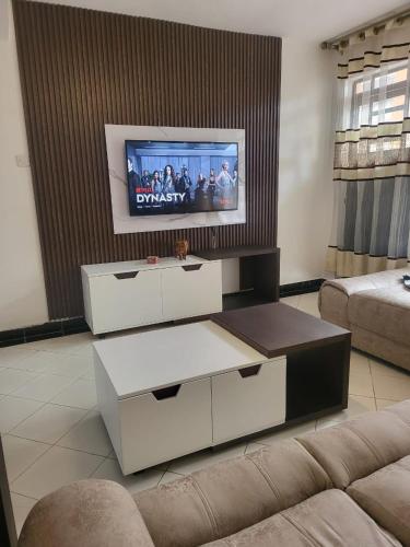 a living room with a tv and a couch at Kim's Executive Three bedroom apartment with outdoor, Nakuru CBD in Nakuru