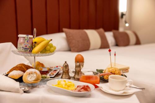een dienblad met ontbijtproducten op een tafel in een hotelkamer bij La Maison de Ville & Suite in Piacenza