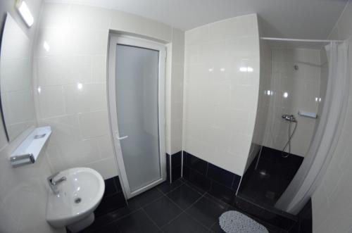 a bathroom with a toilet and a sink and a shower at Vila Rares in Costinesti