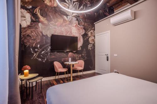 een slaapkamer met een bed en een tv aan de muur bij La Maison de Ville & Suite in Piacenza