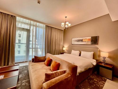 a bedroom with a large bed and a couch at Modern comfort in a compact spacious studio one or two bedroom retreats in Manama