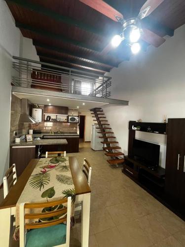 a kitchen and dining room with a table and a staircase at Duplex 2 Villa Ramallo in Estación Ramallo