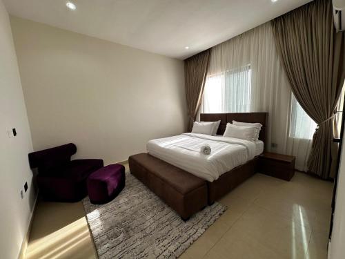 una habitación de hotel con una cama y una silla en SIO APARTMENTs, en Lekki