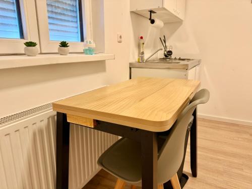 ゲラスドルフ・バイ・ウィーンにあるGER Studio Apartment with Free Parkingのキッチン(木製テーブル、シンク付)