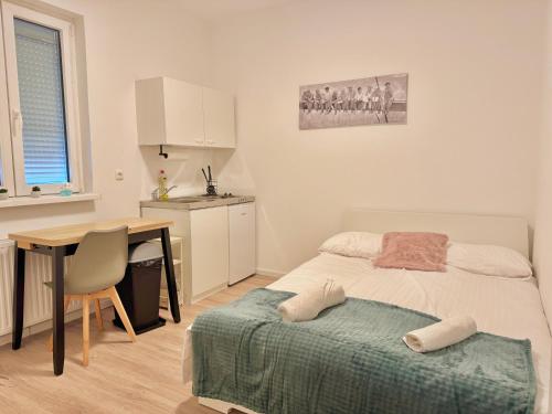 ゲラスドルフ・バイ・ウィーンにあるGER Studio Apartment with Free Parkingのベッドとテーブルとキッチンのある寝室