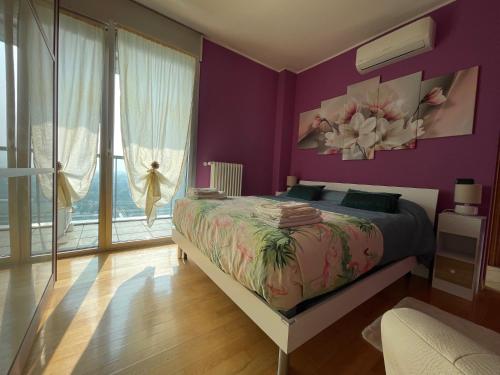 a purple bedroom with a bed and a large window at Skyline 15 Milano - Panoramic Apartment and Free Parking - Metro M1 in Milan
