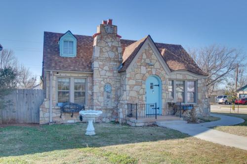 une maison en pierre avec une porte bleue dans l'établissement 1 mile to Fort Sill! The CaroleBelle Cottage sleeps 8 with hottub,grills,firepit, à Lawton
