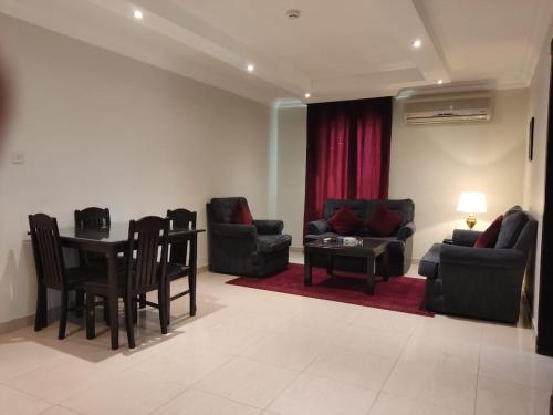 a living room with couches and a table and chairs at 2 Bed Room near GULF DELMON in Al Mubārakīyah