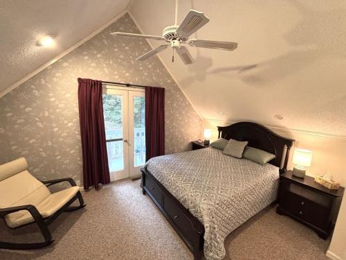 a bedroom with a ceiling fan and a bed and a chair at Quiet and secluded home close to TIEC in Columbus