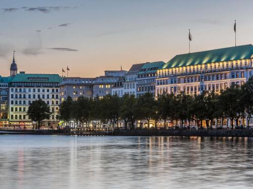 a group of buildings next to a body of water at Fairmont Hotel Vier Jahreszeiten in Hamburg