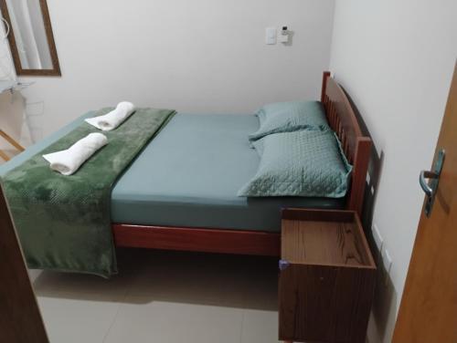 a bed in a bedroom with two towels on it at Apê aconchegante in São José