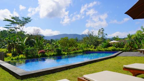 a swimming pool in the yard of a house at Villa Lumbung Sidemen in Sidemen
