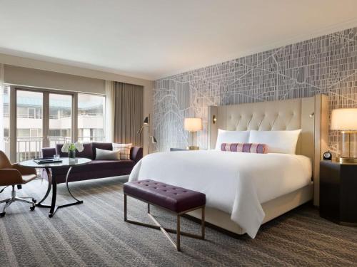 a bedroom with a large bed and a living room at The Fairmont Washington DC in Washington