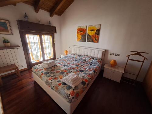 a bedroom with a bed with a comforter on it at CASA BEA Elegante mansarda vicina a Fiera in Pero