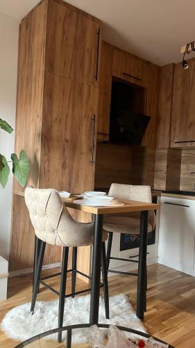 a kitchen with a wooden table and a chair at DreamerLux in Loznica